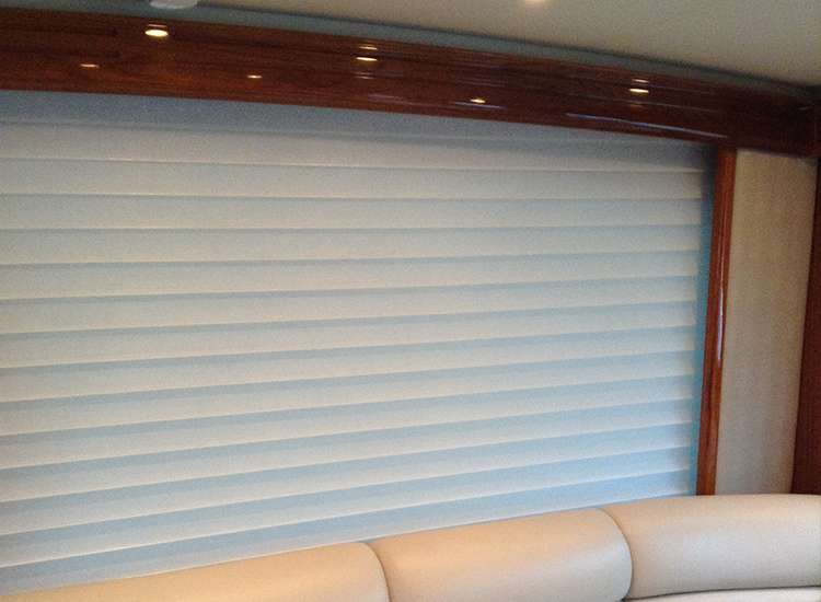 A room with white blinds and wooden trim.