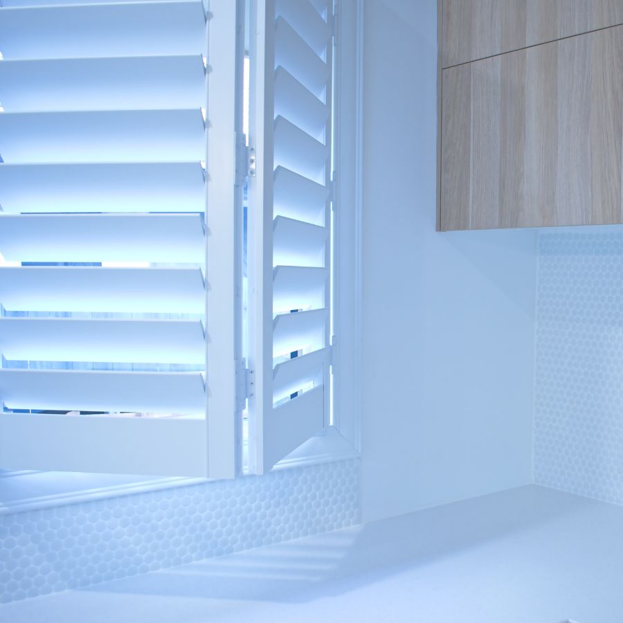 A room with white shutters and a wooden door.